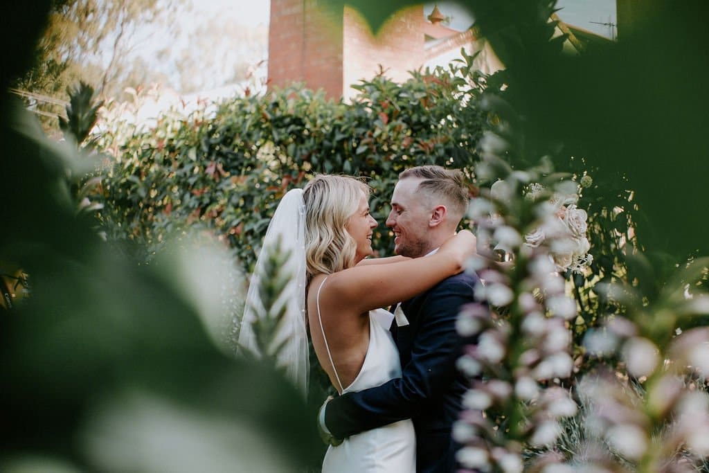 Bride-And-Groom-Embrace-At-Euroa-Butter-Factory-Garden-Wedding